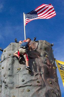 A boy at the top of the rock climbing wall